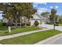 Well-manicured front yard with lush green grass and mature tree enhancing the curb appeal at 6935 Runner Oak Dr, Wesley Chapel, FL 33545