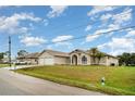Charming house exterior featuring a two-car garage, well-manicured lawn, and a palm tree at 924 Texas St, Englewood, FL 34223