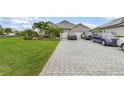 Single-Gathering home featuring a three-car garage, tropical landscaping and a concrete paved driveway that can accommodate multiple cars at 17204 Bullhorn Cir, Punta Gorda, FL 33982