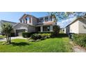 Two-story home with well-manicured lawn, green shrubs and driveway at 7620 Tangle Rush Dr, Gibsonton, FL 33534