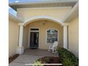 Inviting front entrance featuring an arched entryway and a comfortable rocking chair at 10937 Bluestem Cir, Lakewood Ranch, FL 34202