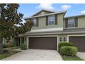 Two-story townhome with brown garage doors, matching shutters and a well-manicured lawn at 20214 Water Hickory Pl, Tampa, FL 33647