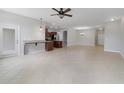 Open concept living room and kitchen area with tile flooring, ceiling fan and natural light at 20214 Water Hickory Pl, Tampa, FL 33647