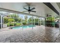 Enclosed lanai with a small pool featuring a paved patio and ceiling fans for comfortable outdoor living at 2421 Valkaria Ave, North Port, FL 34286