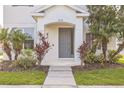 Close-up of a home's entrance with a gray door, manicured landscaping, and clear house number at 5254 Suncatcher Dr, Wesley Chapel, FL 33545