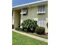 Exterior of building, featuring walkway, plantings, and shuttered windows at 7310 Sunshine Skyway S Ln # 116, St Petersburg, FL 33711