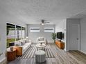 Bright living room with hardwood floors, modern furniture, and a large window overlooking the backyard at 103 4Th Nw Ave, Lutz, FL 33548