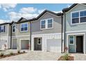 A quaint townhome featuring a one-car garage, brick paver driveway, and well-maintained landscape at 7292 Deer Valley Circle, Tampa, FL 33635