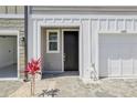 A welcoming townhome entrance featuring a brick paver walkway, landscaping, and a one-car garage at 7292 Deer Valley Circle, Tampa, FL 33635