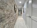 Hallway featuring stone wall, inset lights, tile floor, and white doors at 19700 Gulf Blvd # 204, Indian Shores, FL 33785