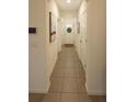 Neutrally decorated hallway leading to the front door and featuring tiled floors at 2913 Suncoast Plains Dr, Odessa, FL 33556