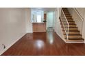 Open concept living room featuring hardwood floors, staircase, and view to the kitchen and entry door at 6600 121St Ave # 5, Largo, FL 33773