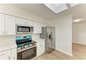 Modern kitchen featuring stainless steel appliances, white cabinetry, quartz countertops, and a skylight at 221 Vermont E Ave, Bradenton, FL 34208