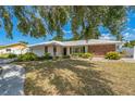 This home has a beautiful lawn with trees and is enhanced with white trim and brick accents at 2521 Carlisle Pl, Sarasota, FL 34231