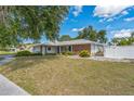 An exterior view of the residence displaying a well-kept lawn and white picket fence at 2521 Carlisle Pl, Sarasota, FL 34231