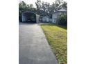 Long driveway with a vehicle shelter leading to the house and detached garage at 4713 9Th E St, Ellenton, FL 34222