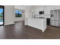 Modern kitchen with a white island, stainless steel appliances, and wood-look flooring at 9573 Migue Cir, Port Charlotte, FL 33981