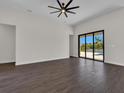 Open living room with sliding glass doors leading to a pool area and a modern ceiling fan at 9573 Migue Cir, Port Charlotte, FL 33981