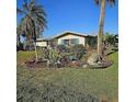 Beautiful home exterior with tropical landscaping, including palm trees and lush plants, enhancing curb appeal at 134 Gulfview Rd, Punta Gorda, FL 33950