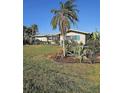 Inviting home exterior with a well-manicured lawn and tropical landscaping, offering a serene view at 134 Gulfview Rd, Punta Gorda, FL 33950