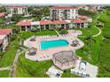 Aerial shot of the community pool, well-maintained green spaces, tiki umbrellas, and bay view at 6218 Palma Del Mar S Blvd # 103, St Petersburg, FL 33715