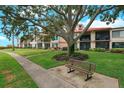 Exterior view of the condo building featuring well-manicured landscaping and a seating area at 6218 Palma Del Mar S Blvd # 103, St Petersburg, FL 33715