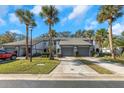 Charming townhome featuring mature palm trees, a private driveway, and manicured landscaping at 4239 Brentwood Park Cir, Tampa, FL 33624