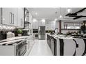 Contemporary kitchen featuring glossy white cabinets, patterned backsplash, and stainless steel appliances at 14448 Woodland Preserve Trl, Parrish, FL 34219