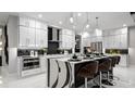 Modern, spacious kitchen with stylish waterfall island, sleek white cabinetry, and stainless steel appliances at 14448 Woodland Preserve Trl, Parrish, FL 34219