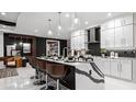 Bright, modern kitchen with island seating, sleek countertops, and decorative hanging lights at 14448 Woodland Preserve Trl, Parrish, FL 34219