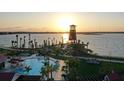 Stunning aerial view of a community pool, lake, and waterfront tower at sunset at 42850 Park View Dr, Punta Gorda, FL 33982