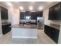 Modern kitchen features dark cabinets, stainless steel appliances, granite countertops, and a center island at 13209 Haystack Ct, Riverview, FL 33579