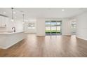 Bright living room with wood-style flooring and sliding glass doors to backyard at 1775 Draughton Dr, Zephyrhills, FL 33541