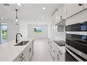Bright, open kitchen with stone countertops, modern appliances, and lots of cabinet space at 1806 Draughton Dr, Zephyrhills, FL 33541