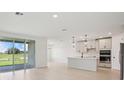 Bright and open floor plan with a modern kitchen, and large sliding glass doors with a lake view at 1806 Draughton Dr, Zephyrhills, FL 33541