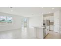 Open-concept living space with tile flooring adjacent to the kitchen at 1817 Draughton Dr, Zephyrhills, FL 33541