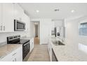 Bright kitchen with granite countertops, stainless appliances, and white cabinets at 3539 Moscato Dr, Brooksville, FL 34602