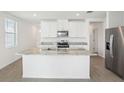 Modern kitchen with stainless steel appliances, granite countertops, and a central island at 3547 Moscato Dr, Brooksville, FL 34602