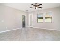 Bright living room with tile flooring, a ceiling fan, and a door to the backyard at 13244 Satin Lily Dr, Riverview, FL 33579