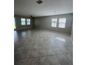 Spacious living room featuring tile floors, abundant natural light, and a modern ceiling fan at 13244 Satin Lily Dr, Riverview, FL 33579