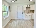 Efficient kitchen area with white cabinets, stainless steel faucet, and laminate flooring at 38706 8Th Ave, Zephyrhills, FL 33542