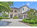 Beautiful home exterior showcasing a well-manicured lawn, paver driveway, and attached garages at 5531 Arnie Loop, Bradenton, FL 34211