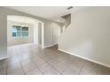 Spacious living room with tile flooring, an arched entryway and staircase with natural light at 10429 Avelar Ridge Dr, Riverview, FL 33578