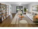 Bright living room with wood floors, white furniture, striped rug, and large sliding glass door at 12800 Kellywood Cir, Hudson, FL 34669