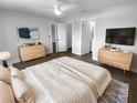 Stylish main bedroom featuring wood floors, modern dressers, and ensuite bathroom at 12800 Kellywood Cir, Hudson, FL 34669