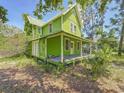 Charming two-story home with a covered front porch, wrapped in mature trees and inviting greenery at 226 N Grosse Ave, Tarpon Springs, FL 34689
