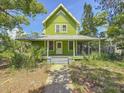The exterior of the home features a welcoming porch, mature landscaping, and a classic two-story design at 226 N Grosse Ave, Tarpon Springs, FL 34689