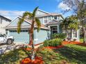 Charming two-story home with a well-manicured lawn, mature trees and a light blue exterior color scheme at 5009 Clover Mist Dr, Apollo Beach, FL 33572