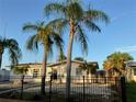 Inviting single-story residence with a black metal fence, complemented by lush palm trees and a rock lawn at 3680 Whiting Se Dr, St Petersburg, FL 33705