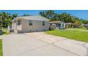 Inviting single-story home with an expansive driveway and lush green lawn at 3850 11Th S Ave, St Petersburg, FL 33711